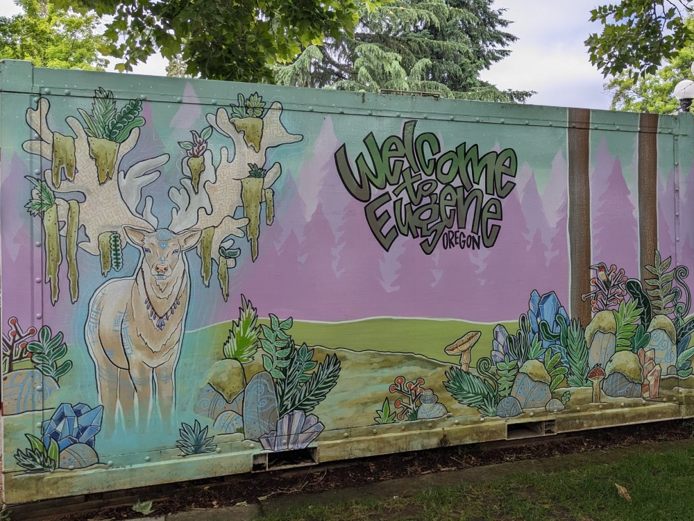 art that says Welcome to Eugene Oregon above a colorful forest with a moose in it